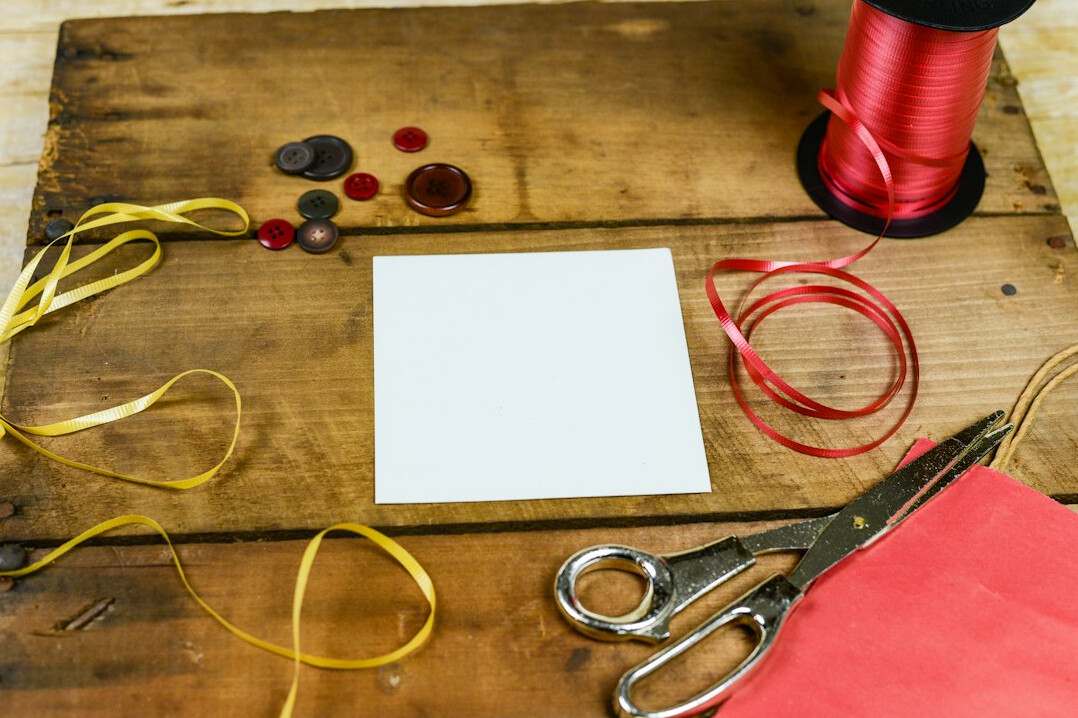 Paper crafting supplies with scissors, colored paper and thread